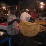 During Ramadan Muslims fast during daylight hours. But when the sun sets the streets around Jama Masjid in Old Delhi fill with food vendors and hungry people. Here a giant fried parantha is lifted from the frying pan. It will be served with sweet semolina halva, cooked with sugar and ghee.